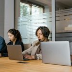Four customer support agents working diligently in an office setting.